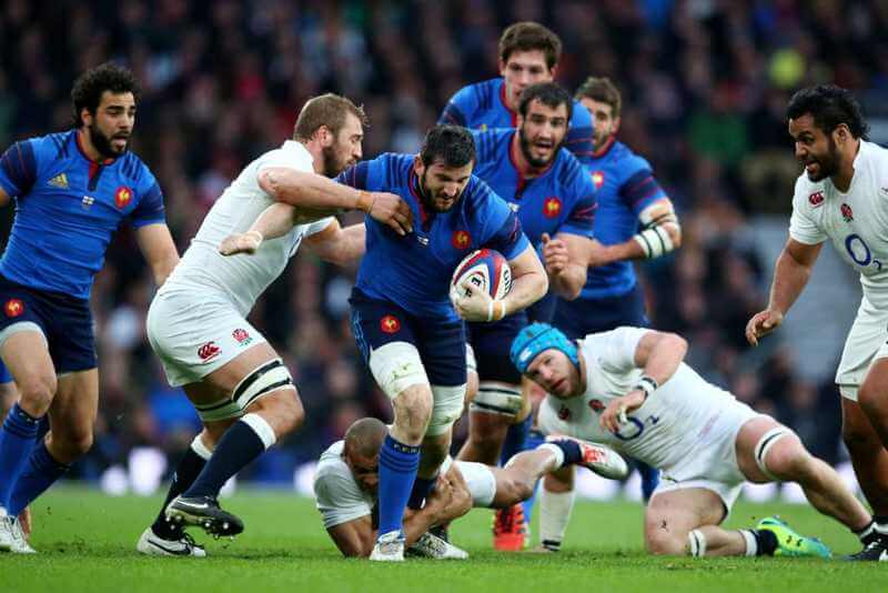Live rugby ruck with scoreboard in background